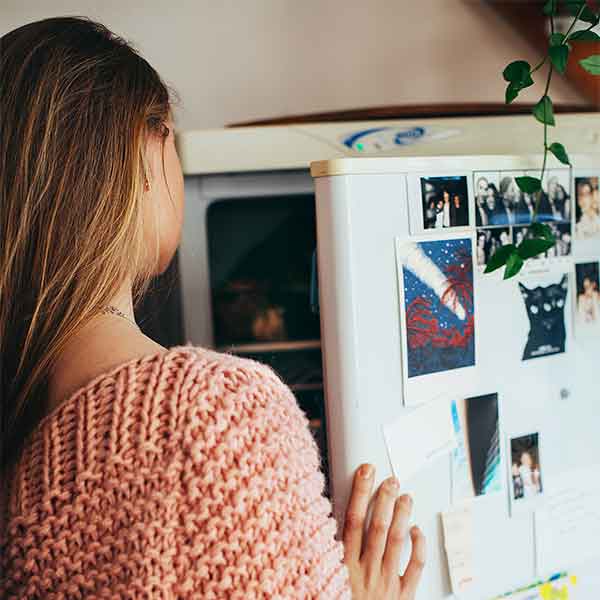 Preserving freezer leftovers - Women looking in fridge and freezer.