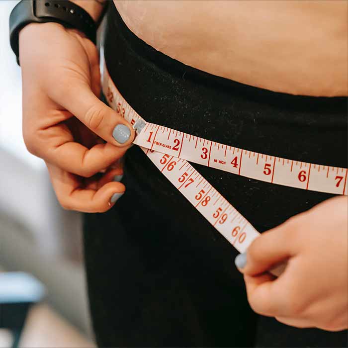 Obese women measuring her waist line